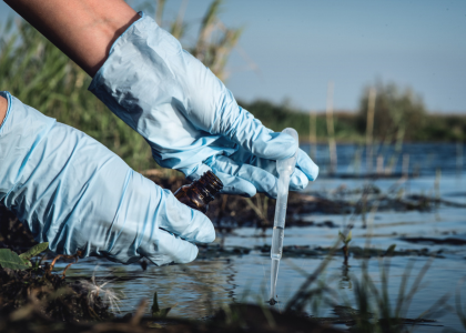 Une personne avec des gants prélévant de l'eau
