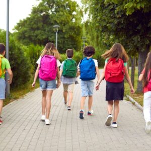Groupe d'écoliers marchant sur un sentier avec leurs sac à dos